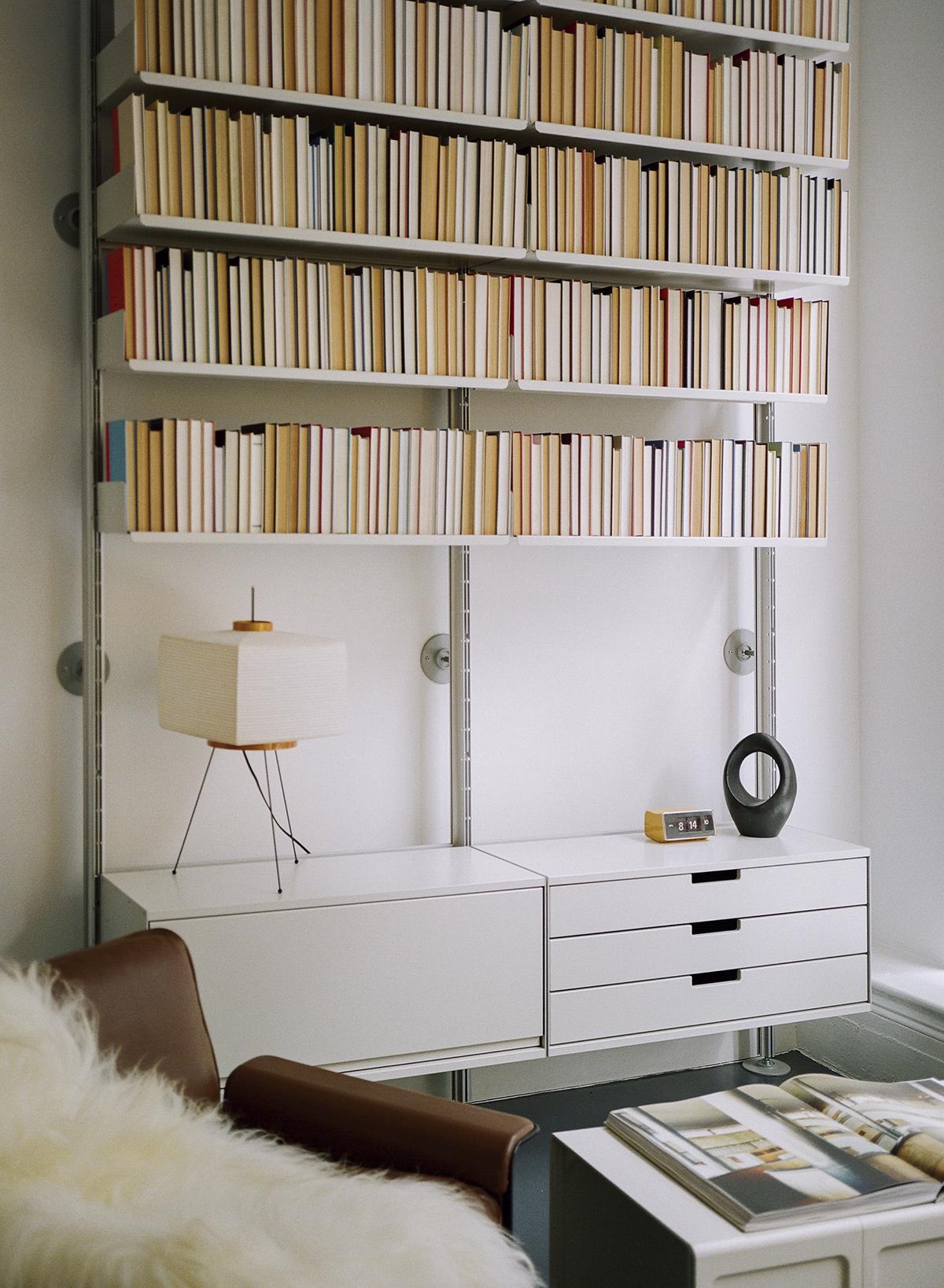 Ein minimalistisches Bücherregal mit farblich sortierten Büchern und modernem Design zeigt, wie organisierte Räume visuell ansprechend wirken.