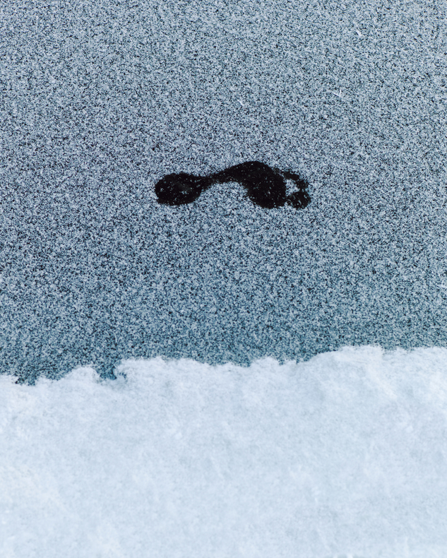 Fußabdruck im Eis, symbolisiert den ersten Schritt ins Eisbaden – eine mentale und körperliche Herausforderung bei kalten Temperaturen.