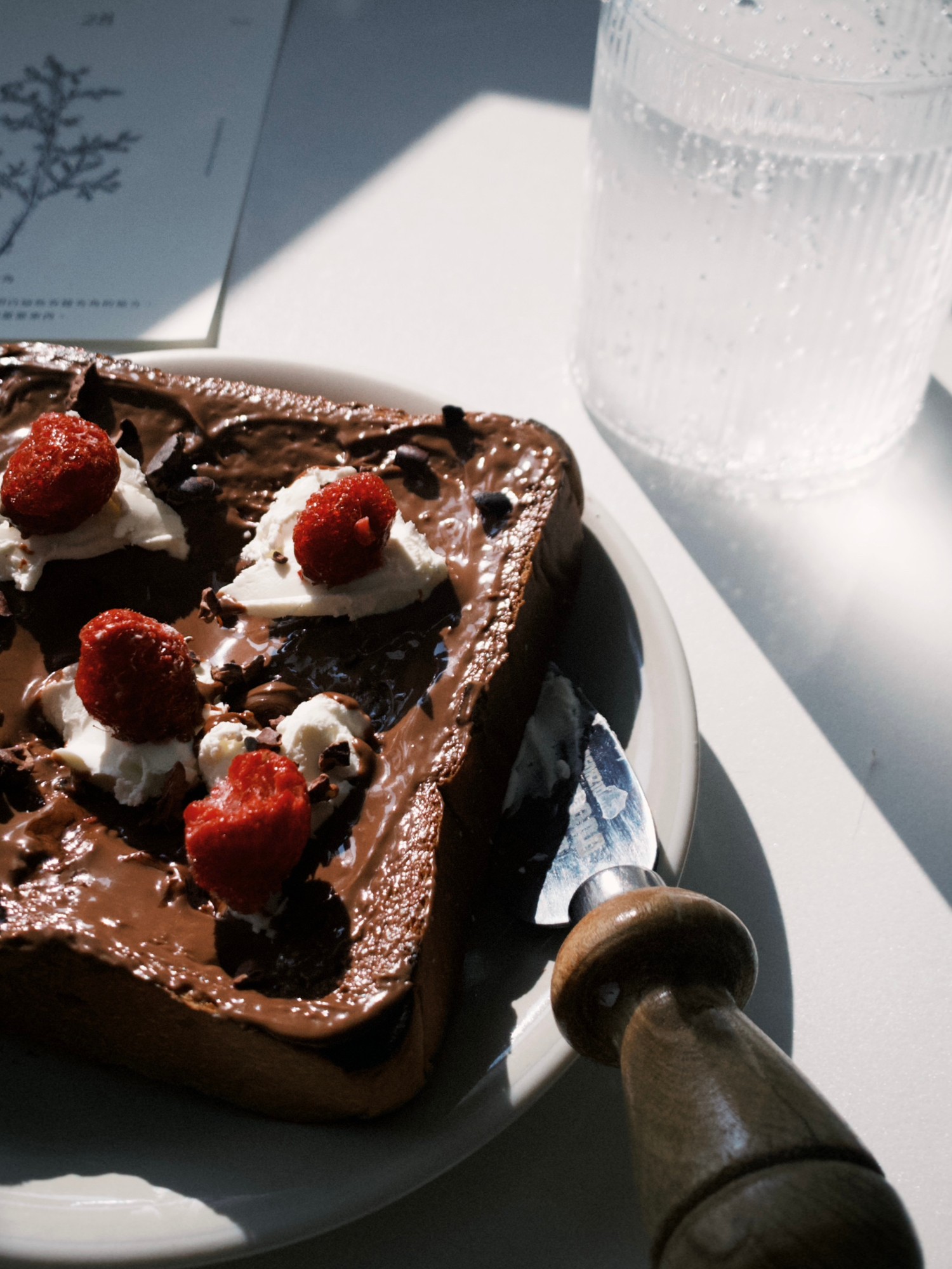 Toast mit Schokoladenaufstrich, Sahne und Himbeeren – zeigt, wie alltägliche Snacks oft versteckte Zuckerquellen sind, die zur übermäßigen Zuckeraufnahme beitragen.