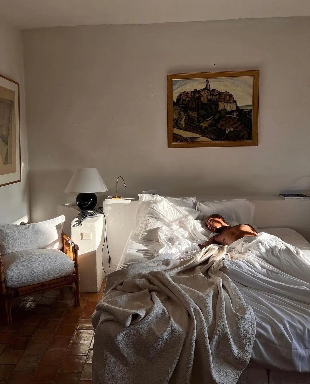 Person, die in der Morgensonne im Bett liegt – eine entspannte Szene, die dazu einlädt, den Tag mit einem frischen Guten-Morgen-Spruch zu starten.