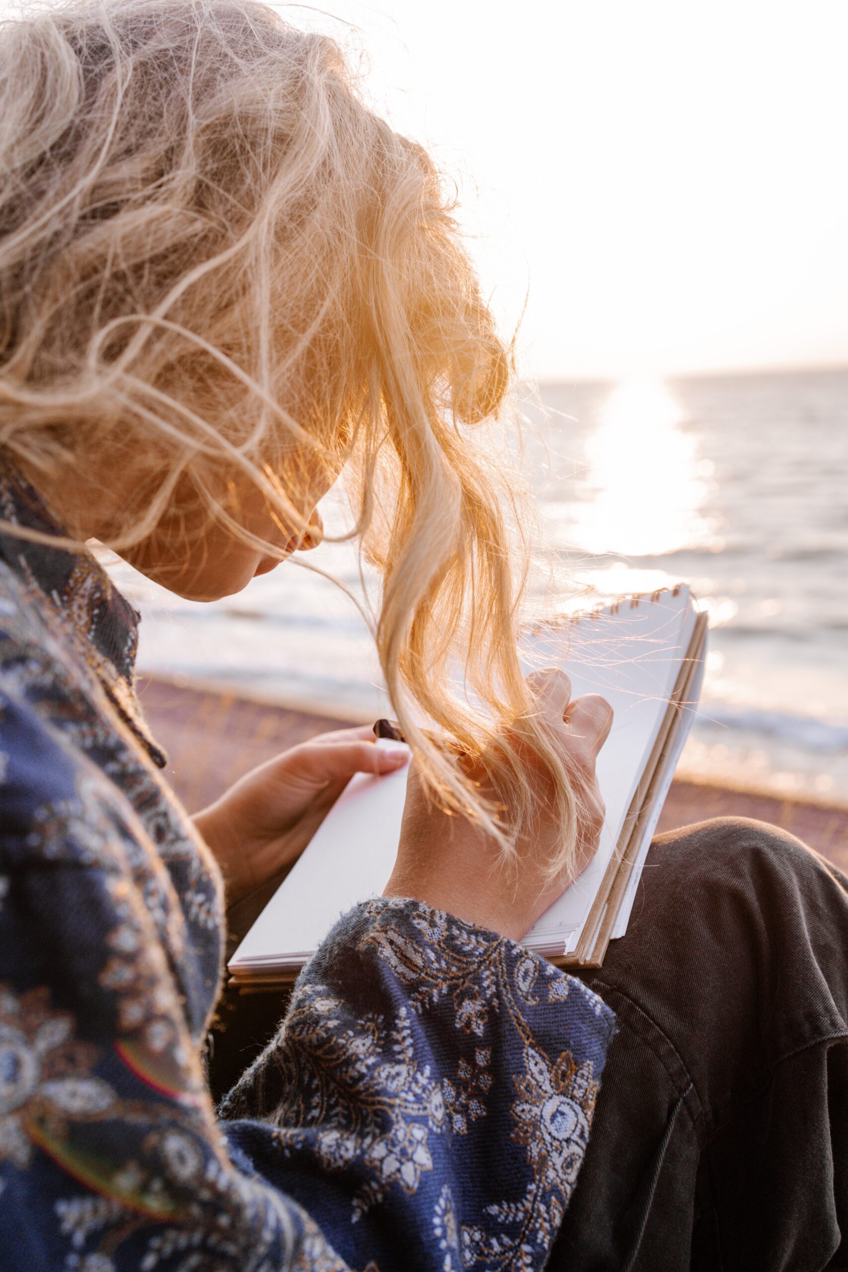 Hypnowriting am Meer: Frau schreibt ihre Gedanken auf